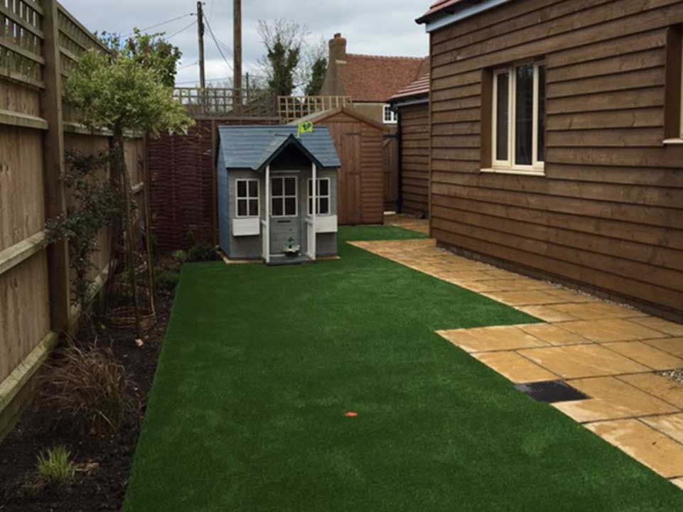 Artificial grass, paving slabs, and play house